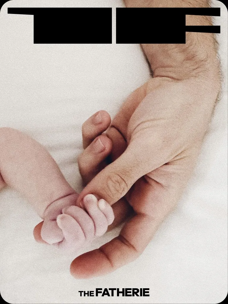 A newborn's hand curled around an adult finger, the Anvil mark above